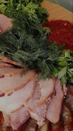 Мясное плато с пряной зеленью на полевой кухне