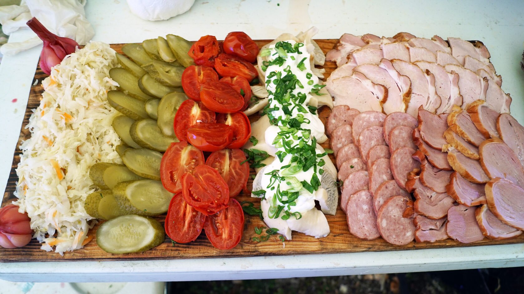 Мясное плато с соленьями и томатами на экспедиционном столе
